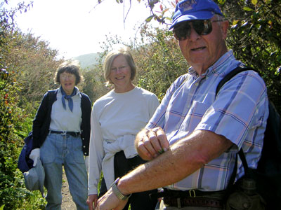 Docent Anita Zehnder, visitor Ann, and Bob Traver, apply ancient Chumash remedy (Mugwort plant) to poison oak exposure on Bob's arm while hiking Coon Creek.